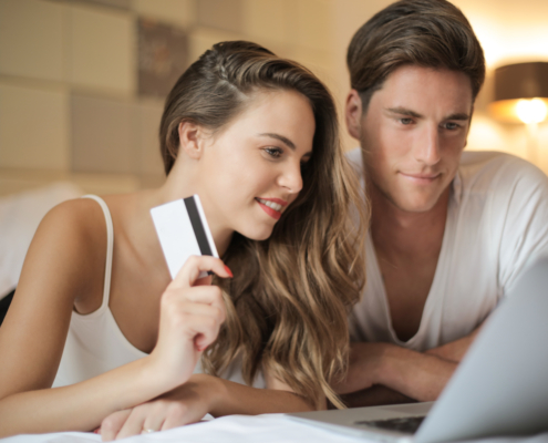 Cheerful couple making online purchases at home