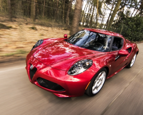 Red alfa romeo c4 on road near trees