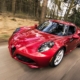 Red alfa romeo c4 on road near trees