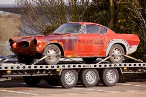 Red coupe on flatbed trailer